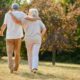 A senior couple go for a walk. They are photographed from behind.